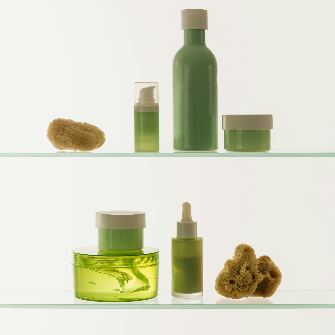 Ästhetische Kosmetikprodukte in grün in einem Glasregal