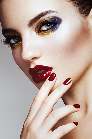 Frau mit dramatischem Partymake-up in Gold und Violett