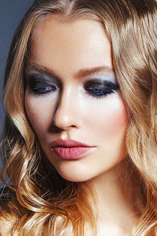 Frau mit dramatischem Partymake-up in Schwarz und Violett