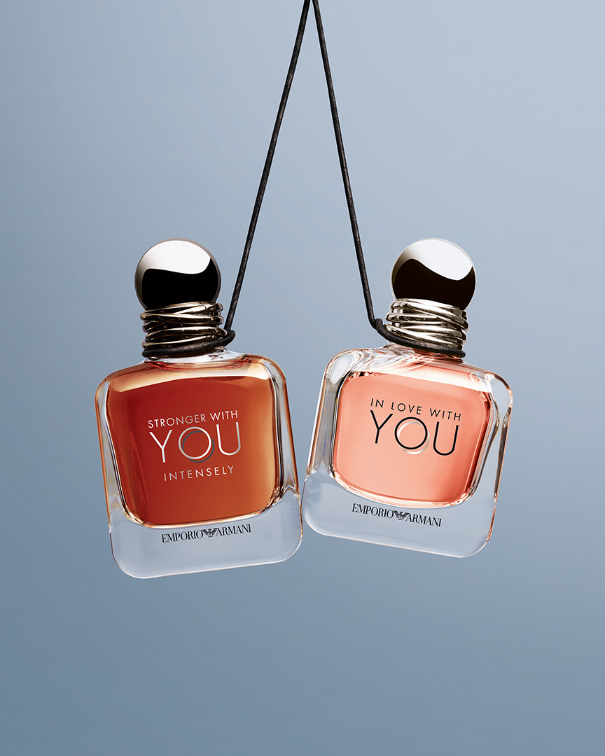 Emporio Armani Düfte Stronger With You Intensely und In Love With You hängen an einer Schnur befestigt in der Luft.