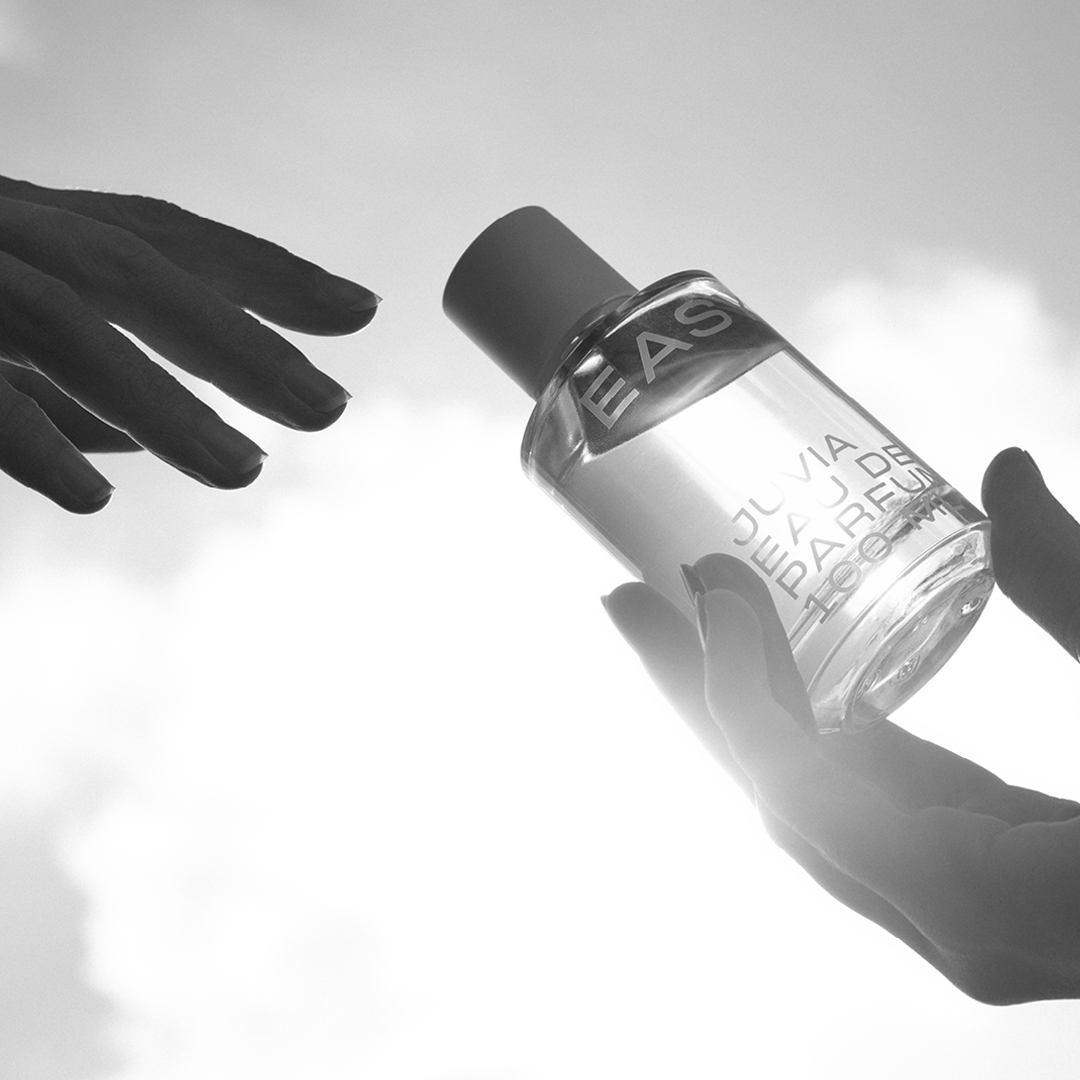 Nahaufnahme Hände, die sich einen Parfumflakon reichen