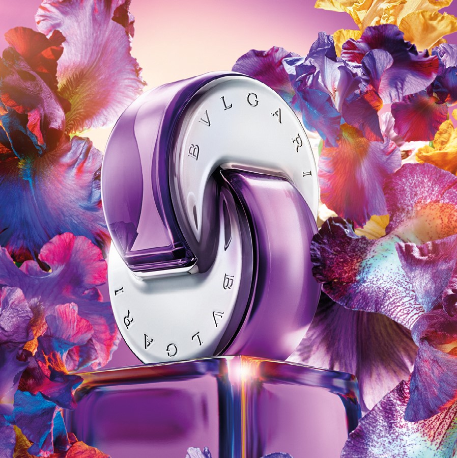 Very Peri Flakon von BVLGARI OMNIA AMETHYSTE umgeben von Blumen